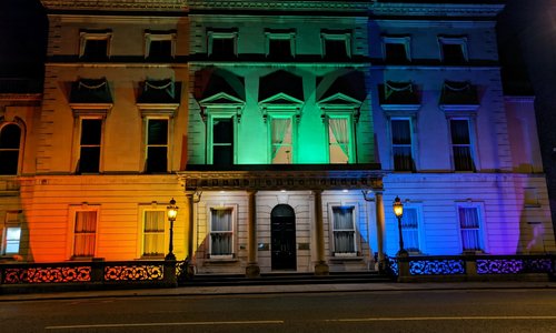 A building lit up with rainbow flag