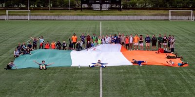Team gathered around enormous Irish flag
