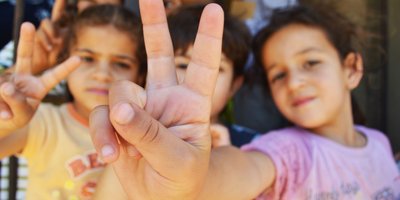 Syrian children making the peace sign