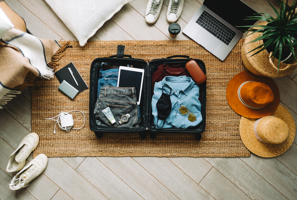 Suitcase surrounded by travel accessories