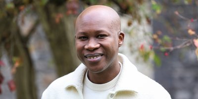 Man smiling with foliage in the background