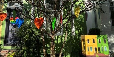 Little free library that resembles yellow and green row houses it sits in front of in Capitol Hill