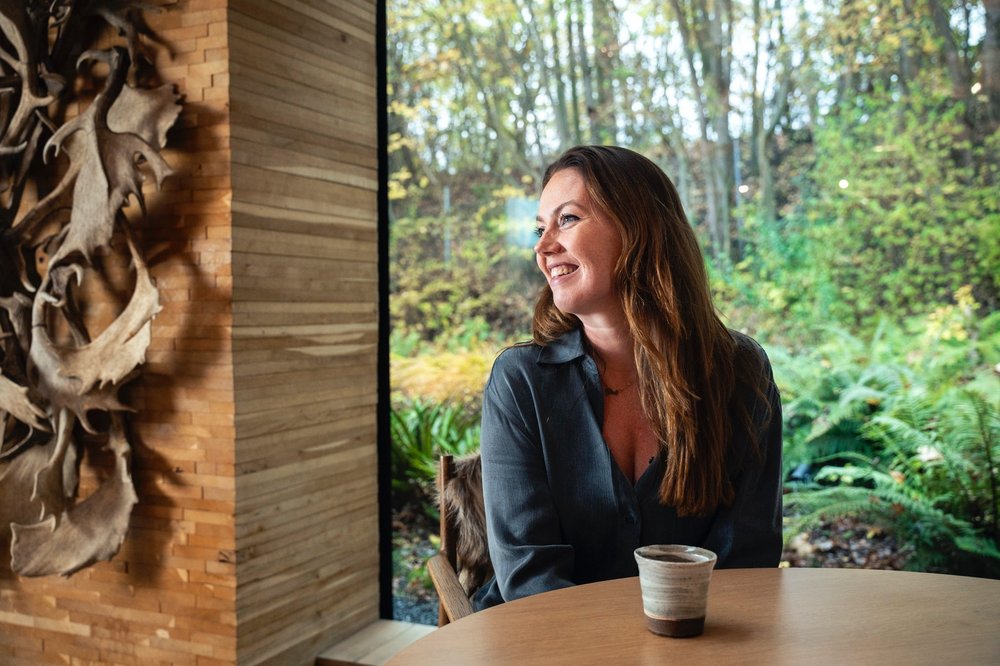 Woman sitting at a table smiling to the left