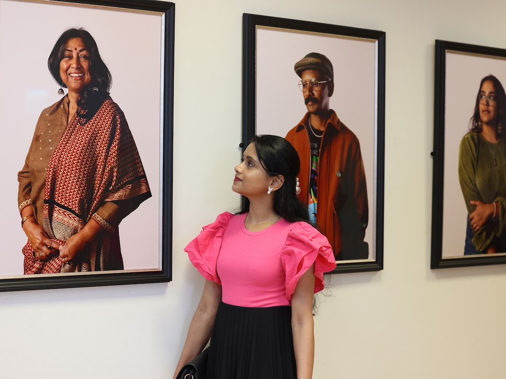 A woman looking at a framed portrait of another woman
