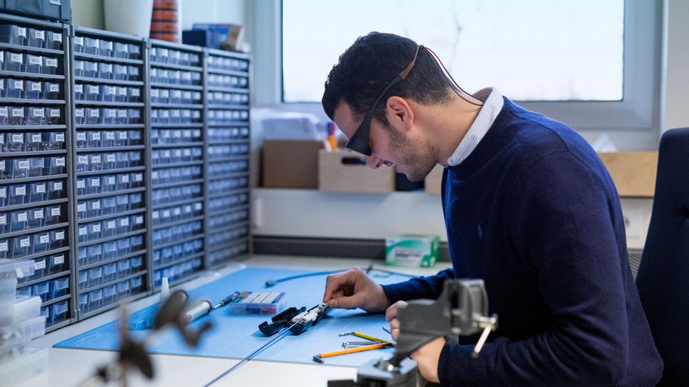 Scientist with magnifying goggles on working on equipment
