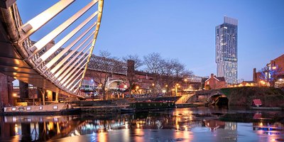 A view of Manchester from beneath a bridge at twilight.