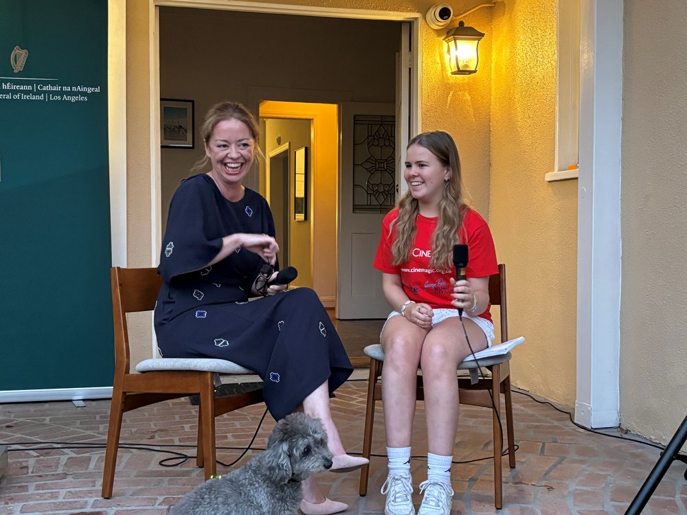 A student interviewing the Consul General of Ireland to LA, Marcella Smyth. They are laughing.