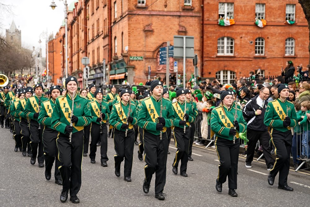 Marching band wearing green uniforms