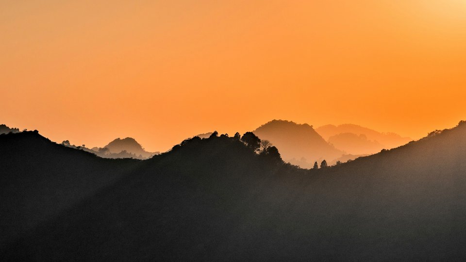 Margala Hills, Islamabad covered in mist with an orange sky above.