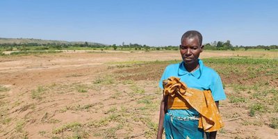 A woman standing in a field washed away by a cyclone