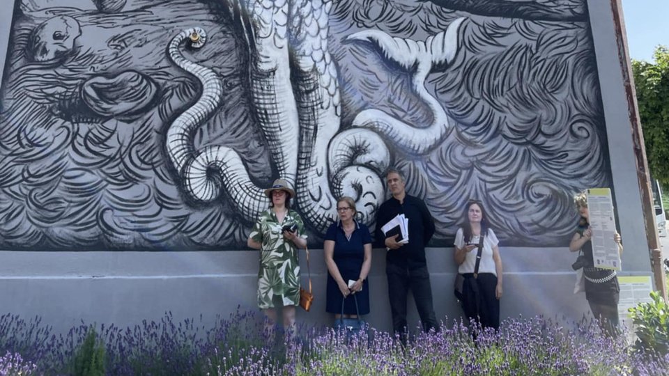 Mural artists standing infront of one of their Murals