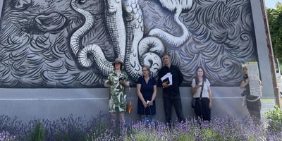 Mural artists standing infront of one of their Murals