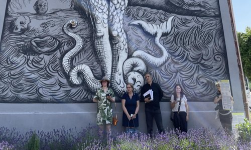 Mural artists standing infront of one of their Murals
