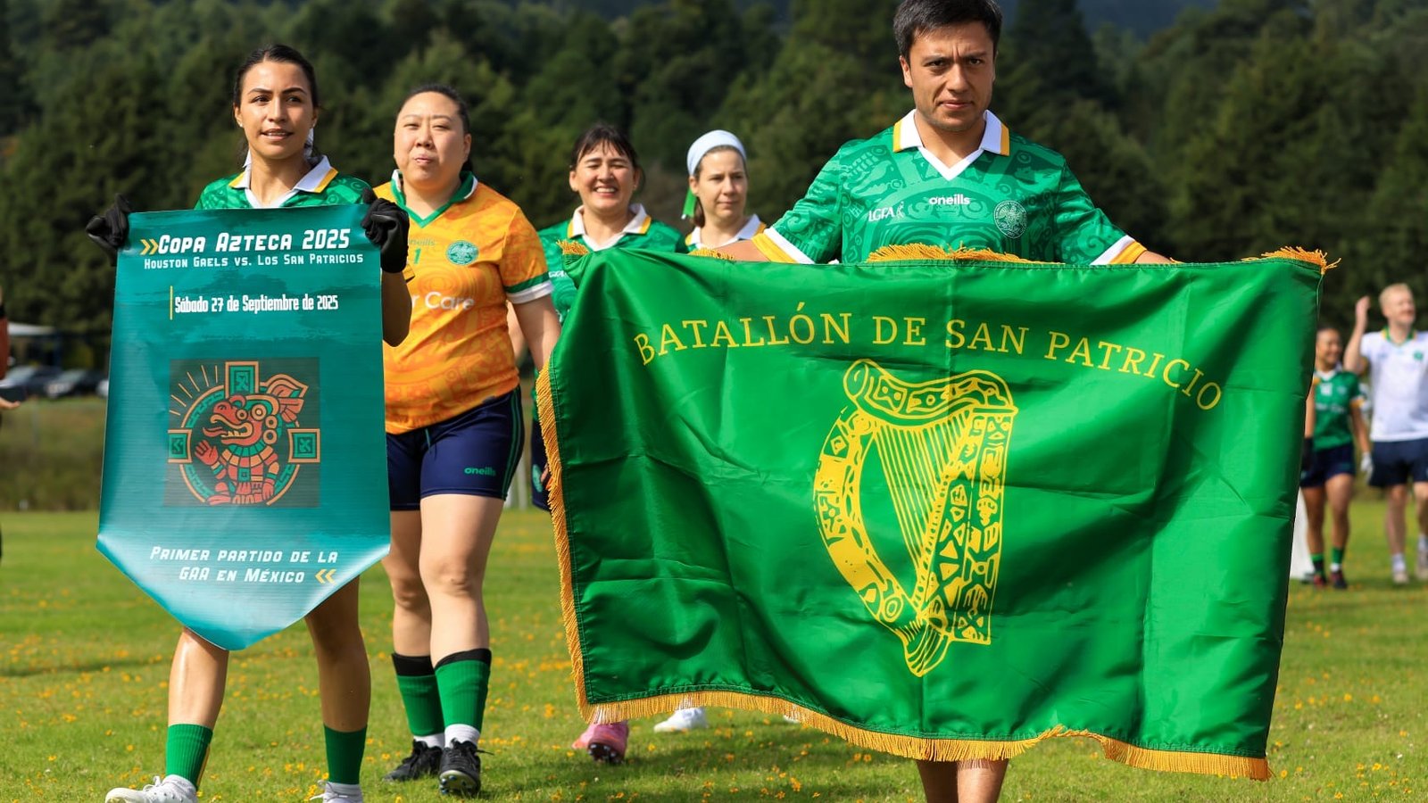 People on a football field carrying a green flag