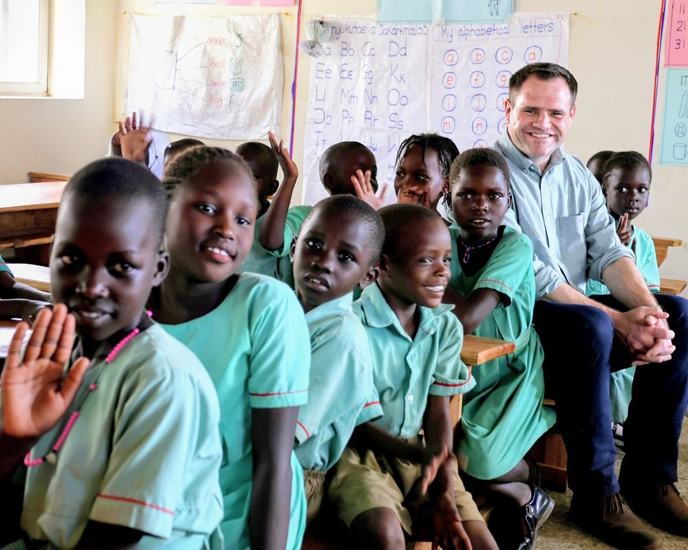 Minister Richmond with pupils at a school in Karamoja