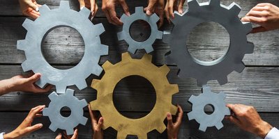 cogs and wheels with hands holding them