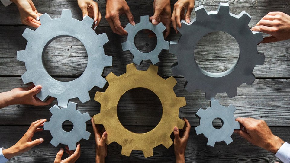 cogs and wheels with hands holding them