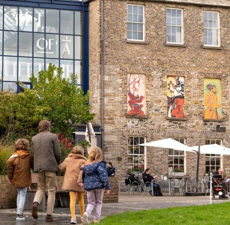 a family with one father and three children walking by green grass to walk into Chester Beatty Library. Big Style Media ©Failte Ireland
