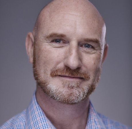 Bald man smiling wearing a shirt