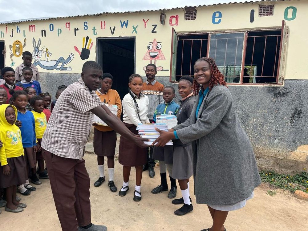 Nsobe Primary Head and Pupils donating books to Pendeni
