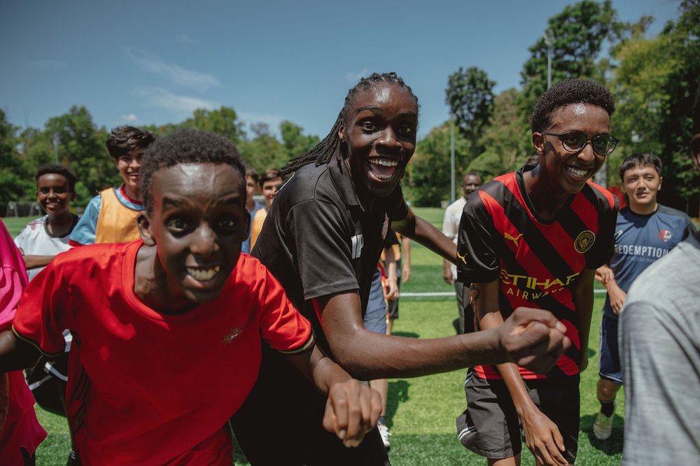 Members of the Refugee Academy programme smiling enthusiastically