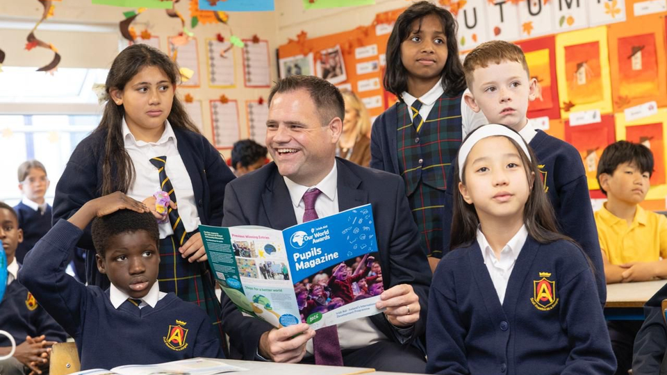 Children sin a classroom with Minister Richmond