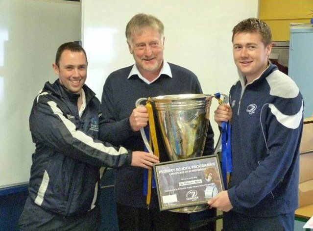 Three men in leinster rugby gear holding a trophy