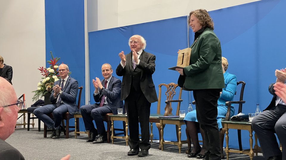 Loretta receiving an award from President Higgins