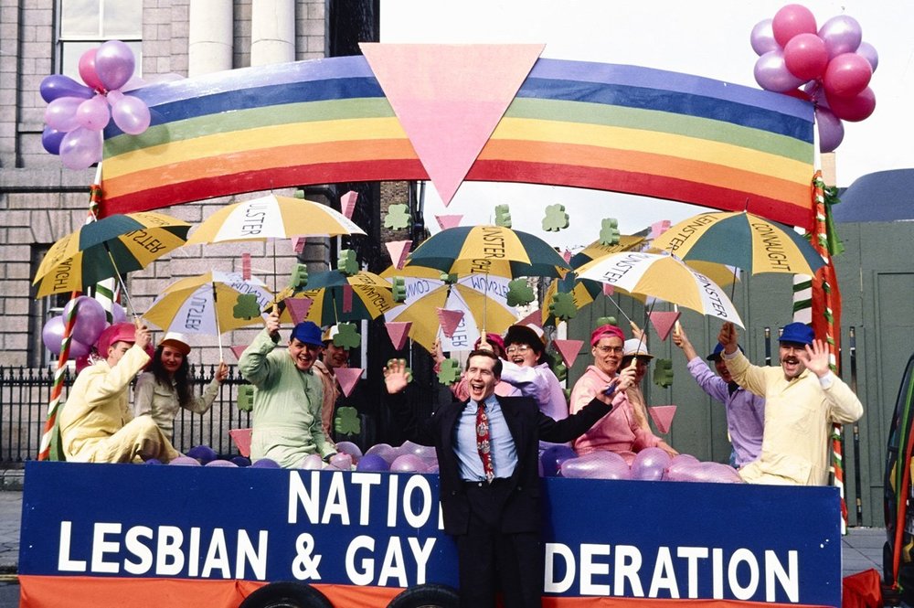 A man posing infront of a pride stand