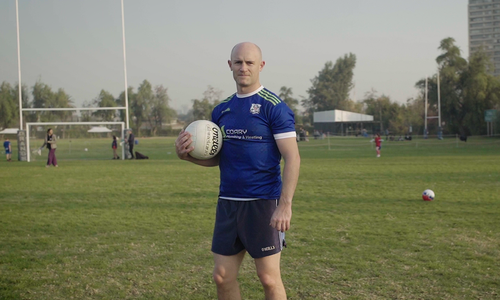 Paddy Coary holding a Gaelic football on a pitch