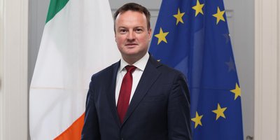 Consul General Peter Neary's headshot beside the Irish and European flag