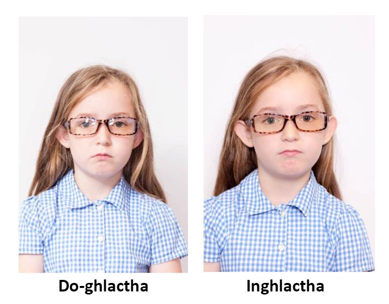 Dhá sheat cinn de chailín óg. Sa cheann atá marcáilte do-ghlactha, tá an cailín ag caitheamh spéaclaí le dallrú orthu. Sa ghrianghraf inghlactha, feictear í deasaithe gan dallrú ar a spéaclaí.