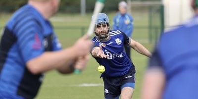A pitcher throwing a ball to a batsman in rounders.