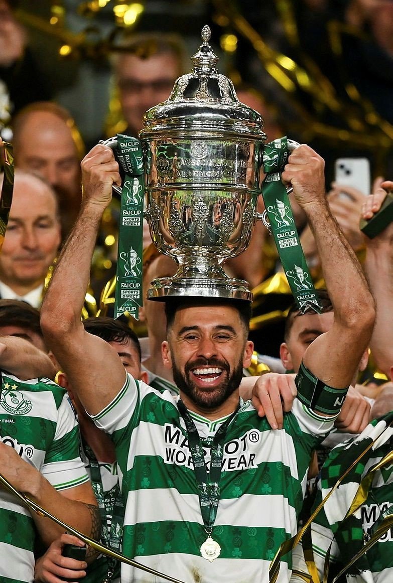 Roberto Lopes holding a football trophy aloft