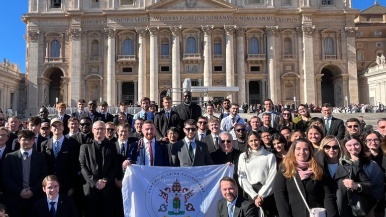 Students outside the Pontifical Irish College in Rome holding a flag