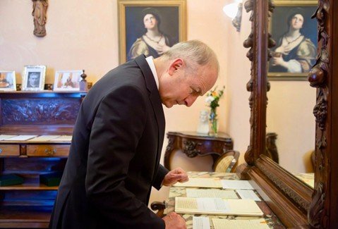 Man in a suit looking at old documents