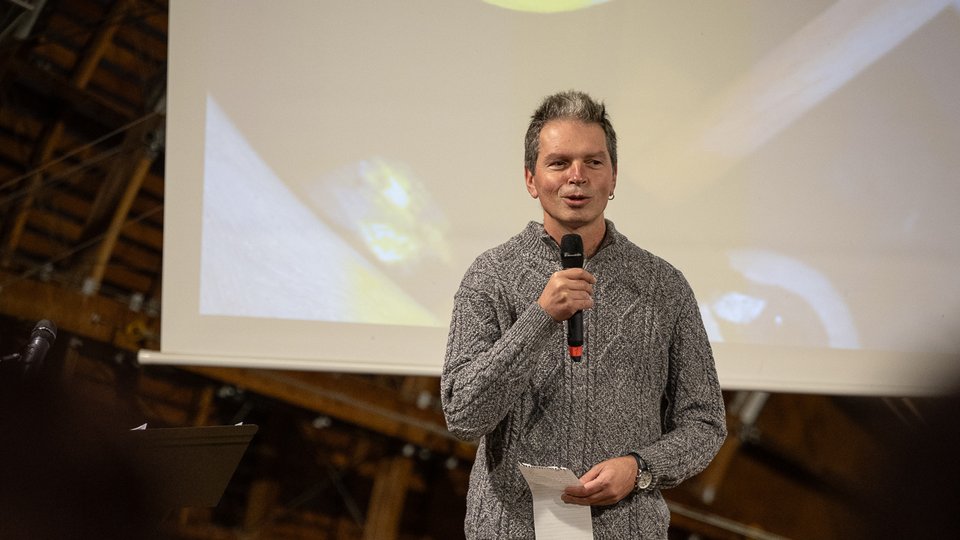 A man standing on stage speaking into a microphone
