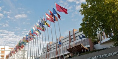 flags in front of a stadium like building