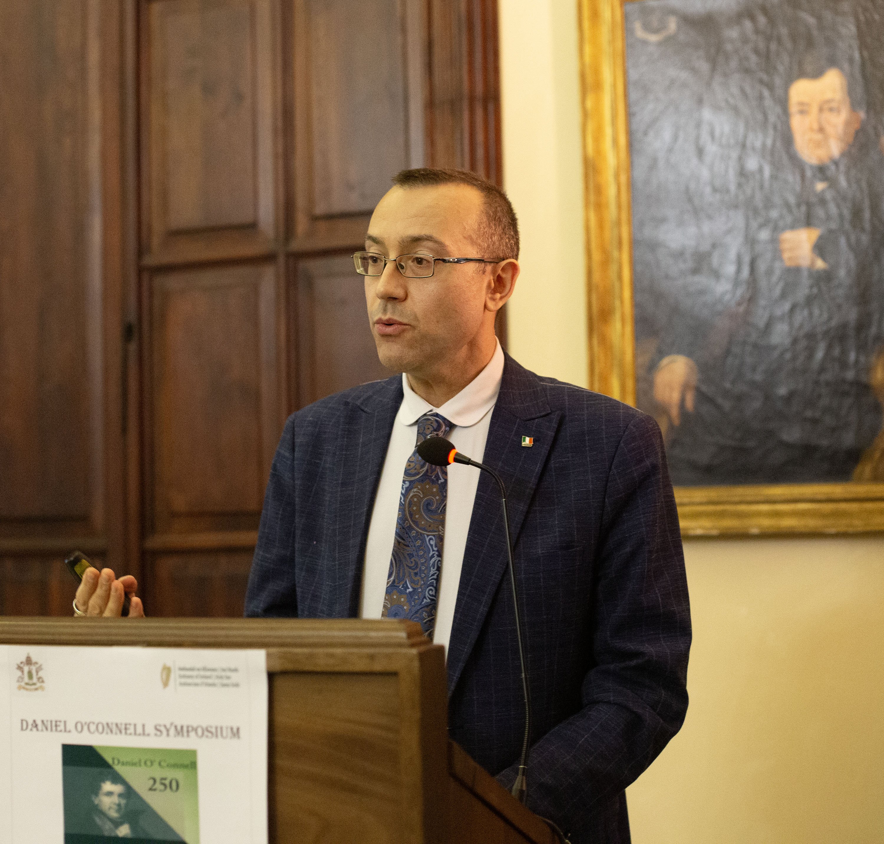 Man speaking at a plinth