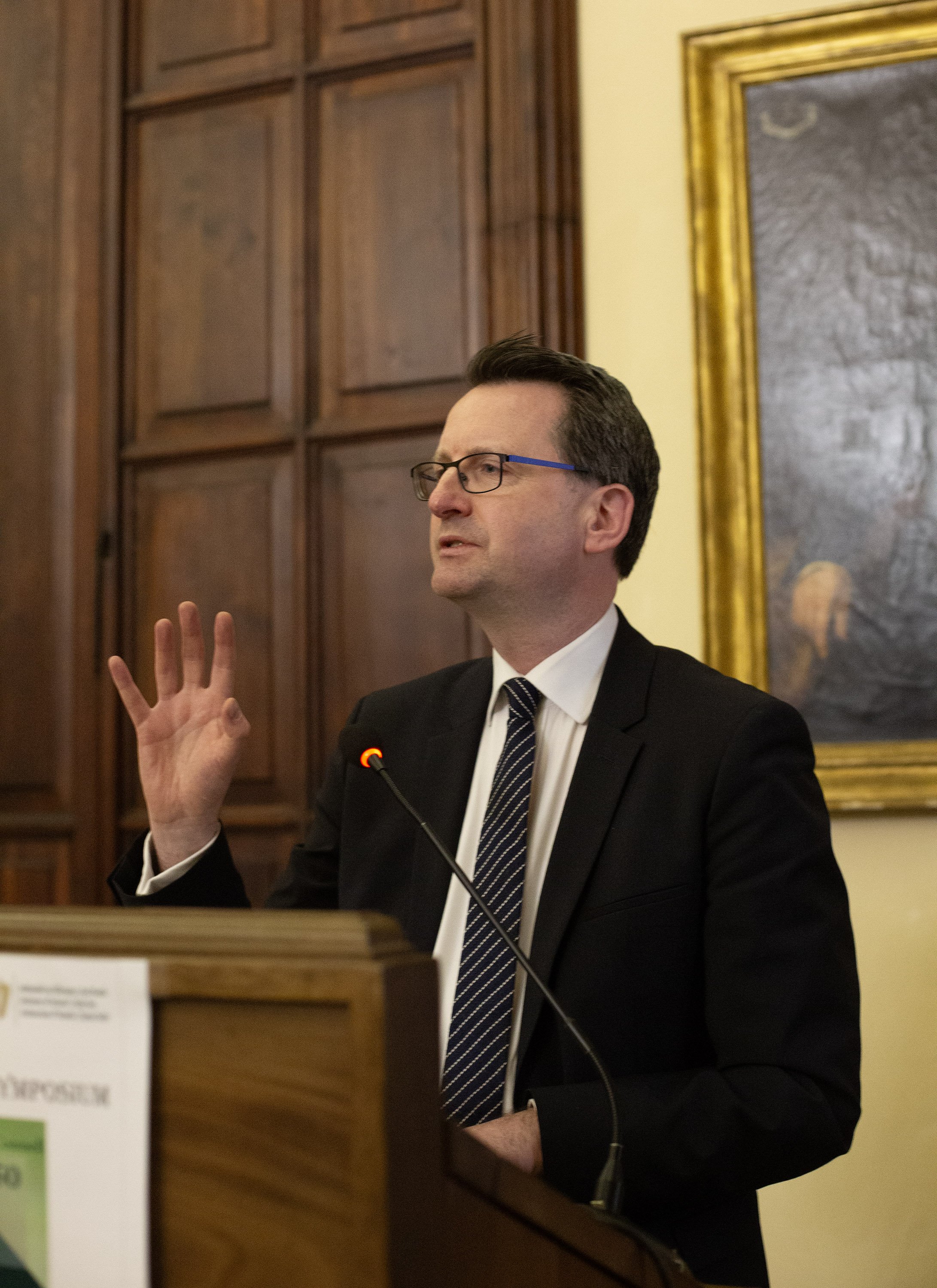 Man speaking at a plinth
