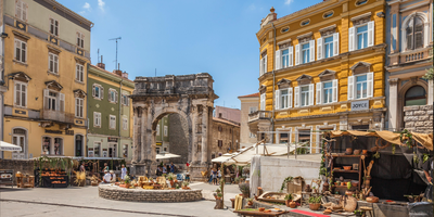 Pula, Croatia. Ancient Roman triumphal arch or Golden Gate and square decorated for the Days of Antiquity