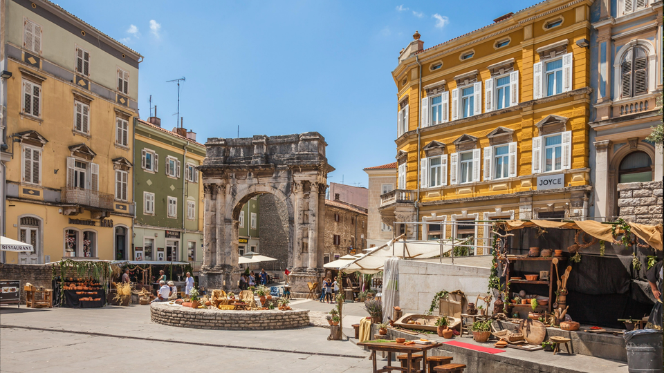 Pula, Croatia. Ancient Roman triumphal arch or Golden Gate and square decorated for the Days of Antiquity