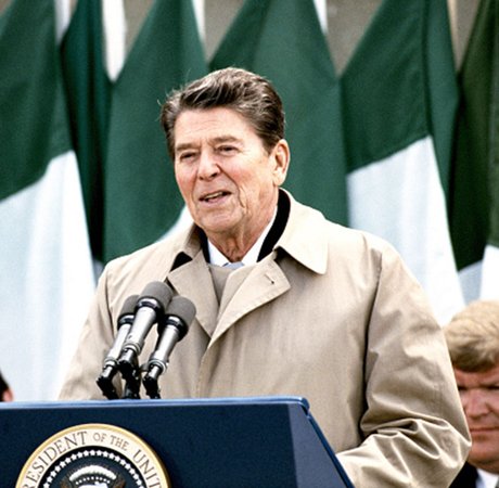 one man speaking at a podium with three microphones
