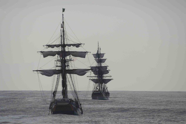 Two ships sailing away at sea