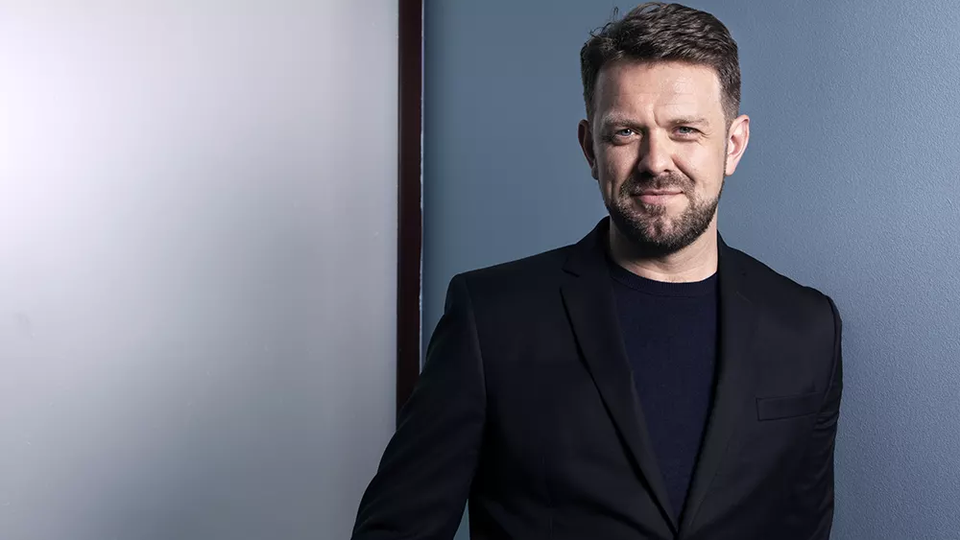 one man looking at camera in a black suit