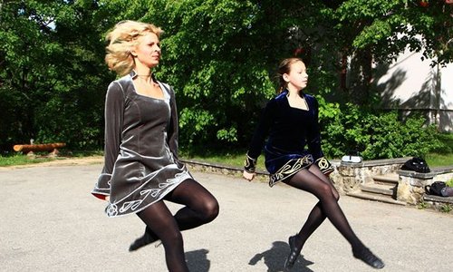 Two Irish dancers dancing in a park