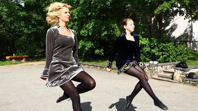 Two Irish dancers dancing in a park