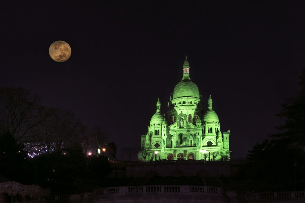 Sacre Coeur cathedral in Paris illuminated in green light for St Patrick's Day