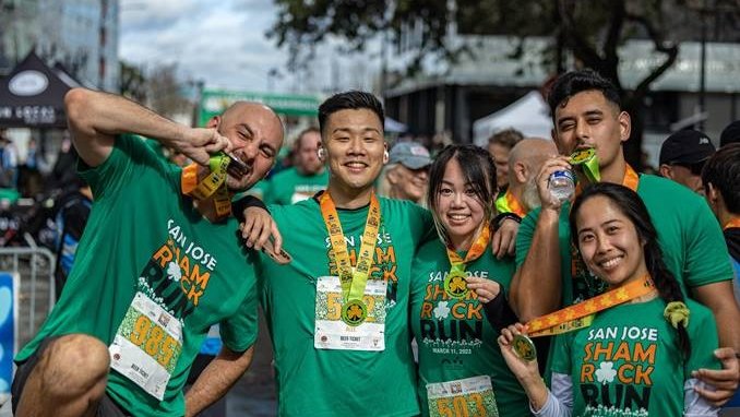 people posing wearing green tshirts and medals for the Shamrock Run in San Francisco