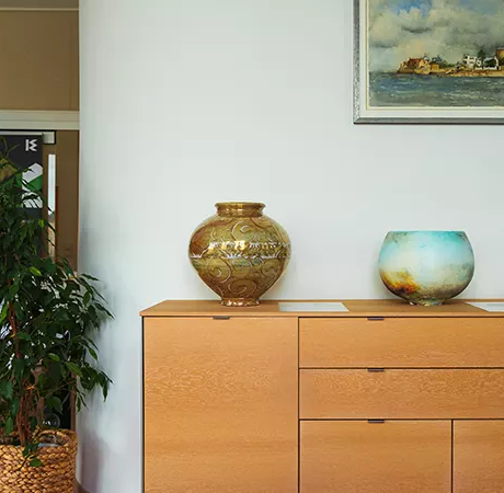 three colourful bowls on a wooden sideboard